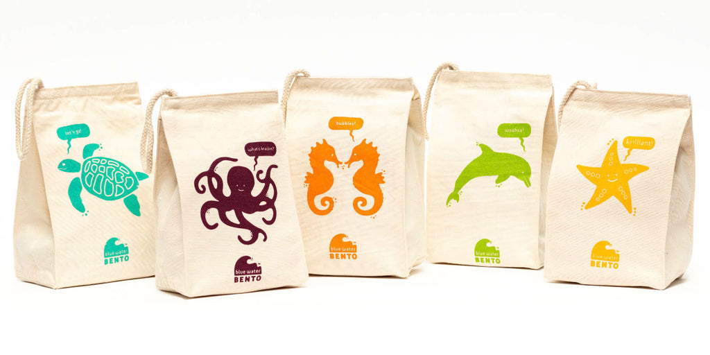 Lineup of five cloth lunchbags each featuring a different colored illustration of sea creatures.